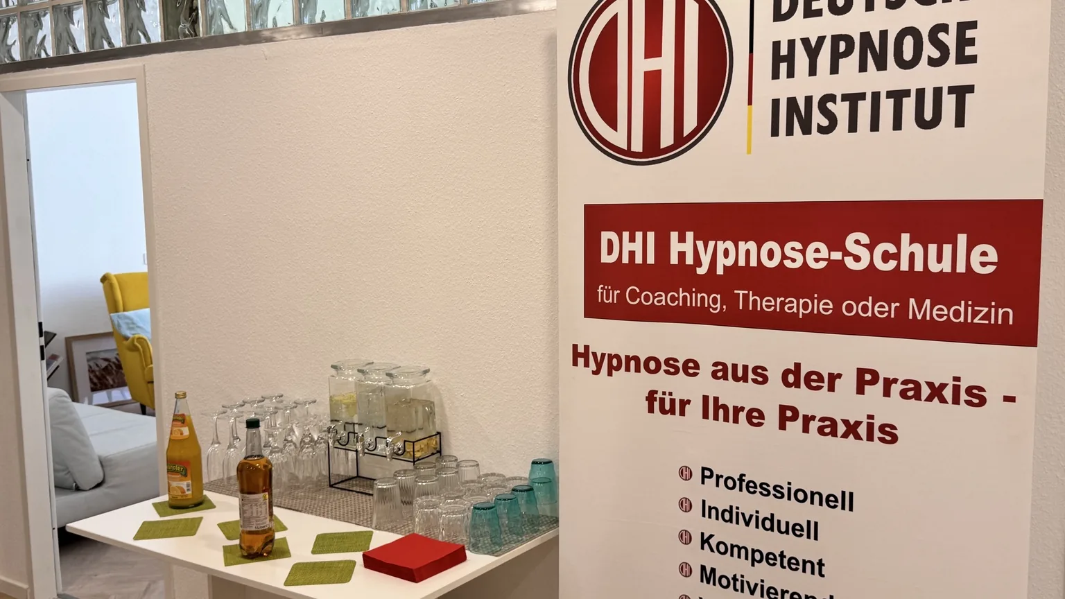Empfangsbereich mit Getränken, DHI-Banner und Blick in den Coachingraum